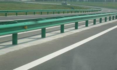 a highway guardrail formed of green PVC coated W-beam guardrails
